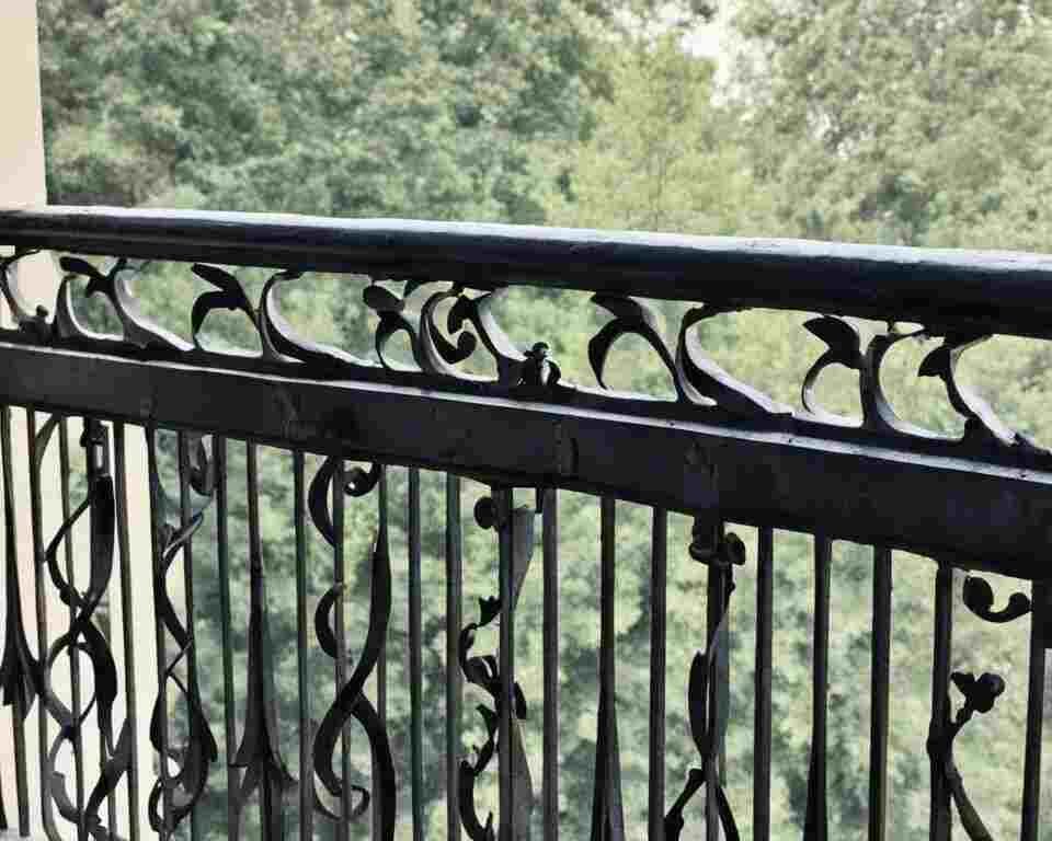 A close-up view of a balcony railing with cracks or signs of wear and tear.